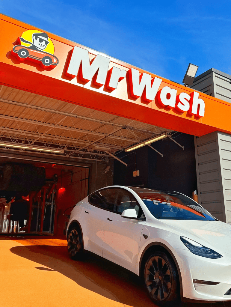 White Tesla car driving through Mr Wash Car Wash express car wash in Tysons Corner Virginia
